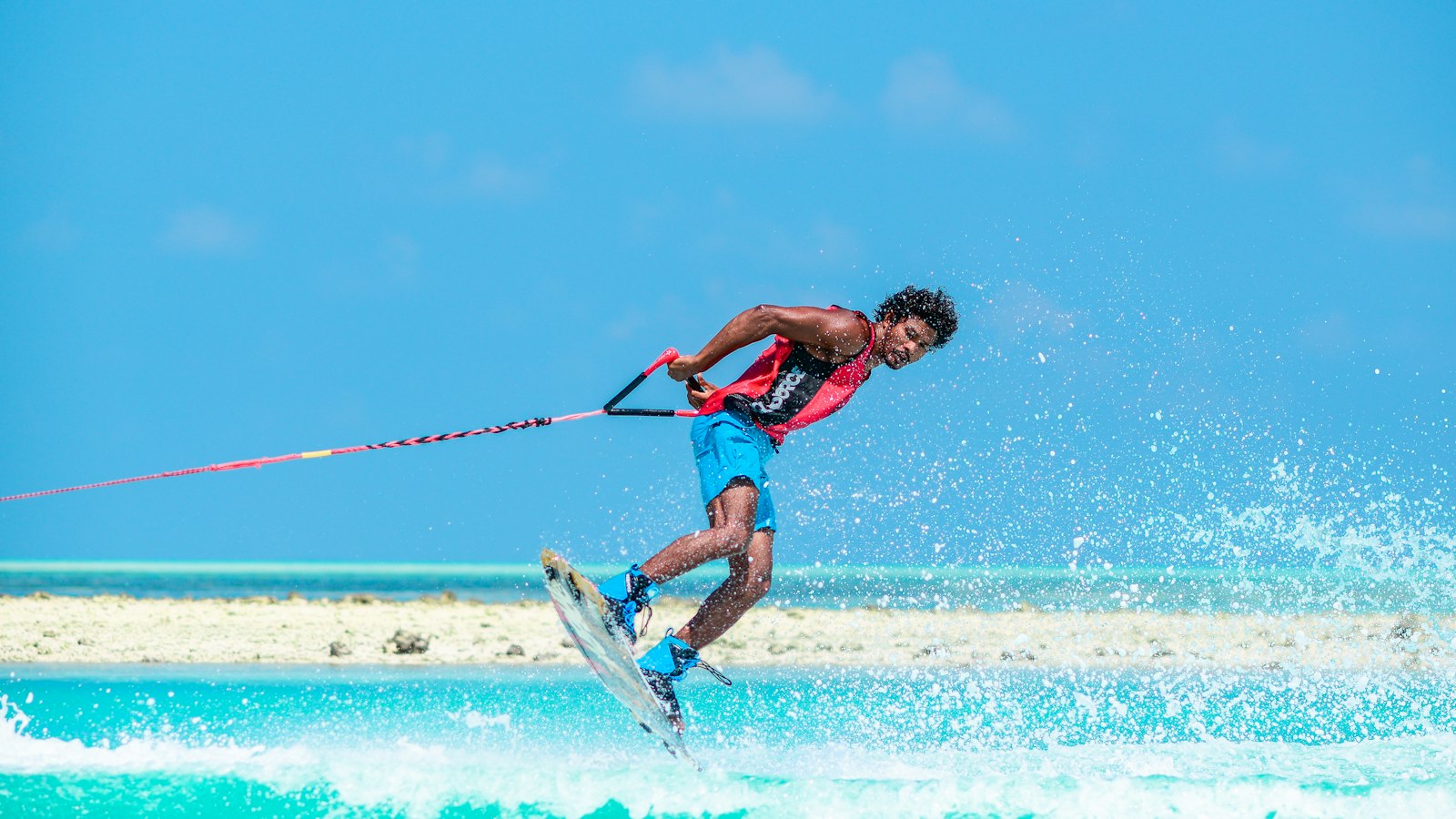 man in red tank top doing water sports during daytime