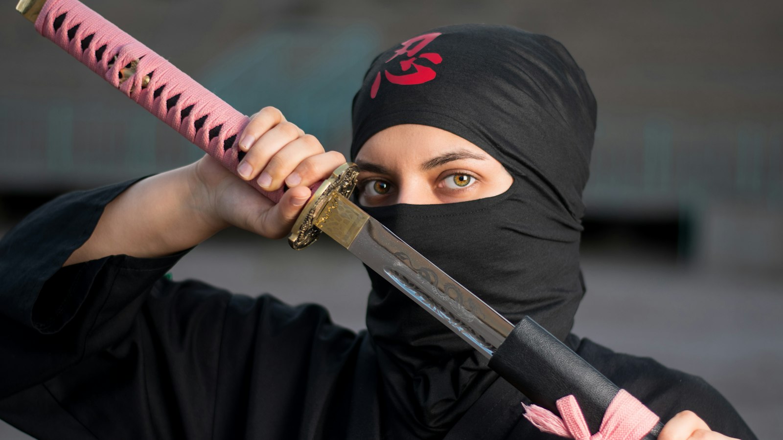 woman in black hijab holding pink and black sword