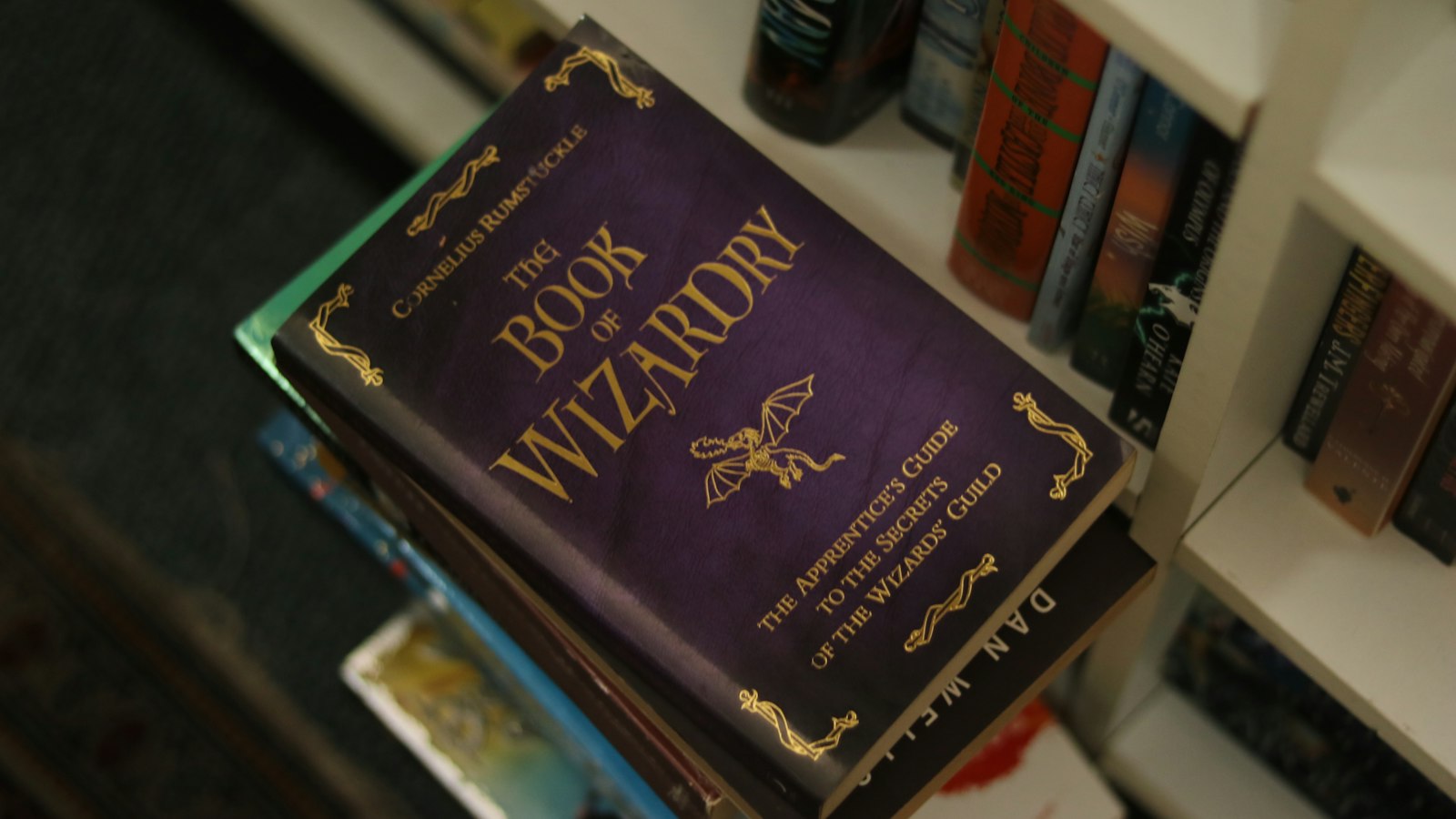 The book of wizardry rests on a stack of books