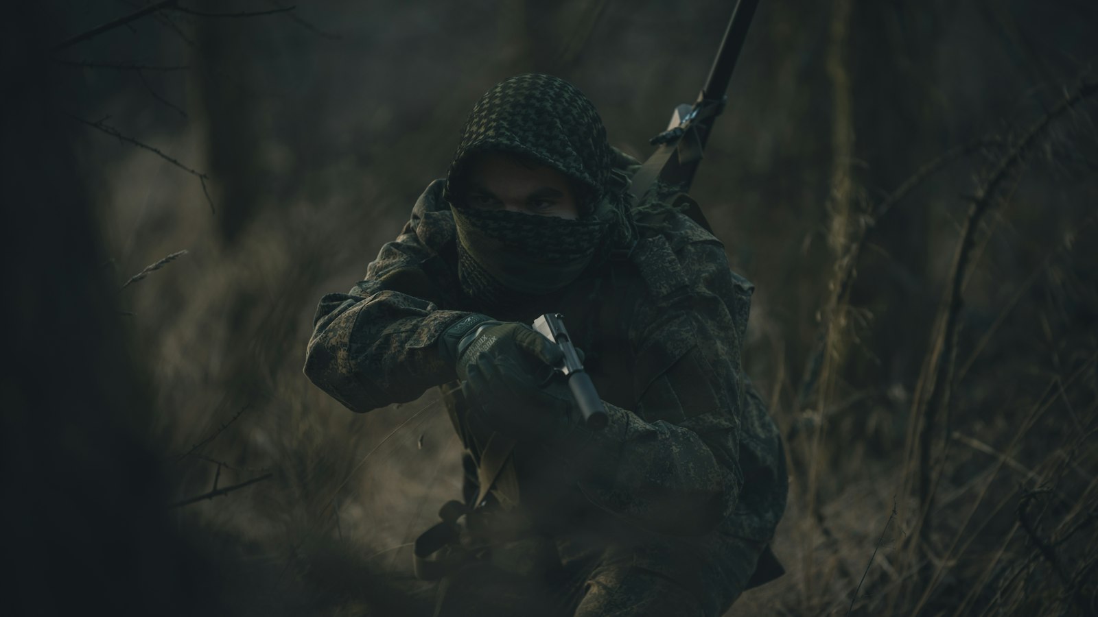 person in black and white hoodie holding rifle